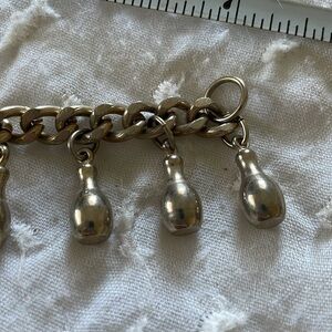 1960s bowling ball & 10 pin charm bracelet. Silver toned pins & black ball.